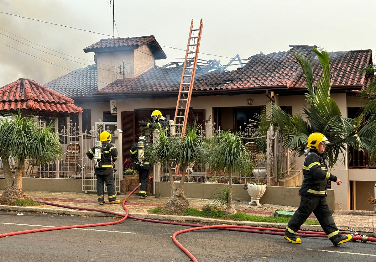 Socorristas no combate ao incêndio que começou no telhado (Foto: Henrique Paulo Koch)