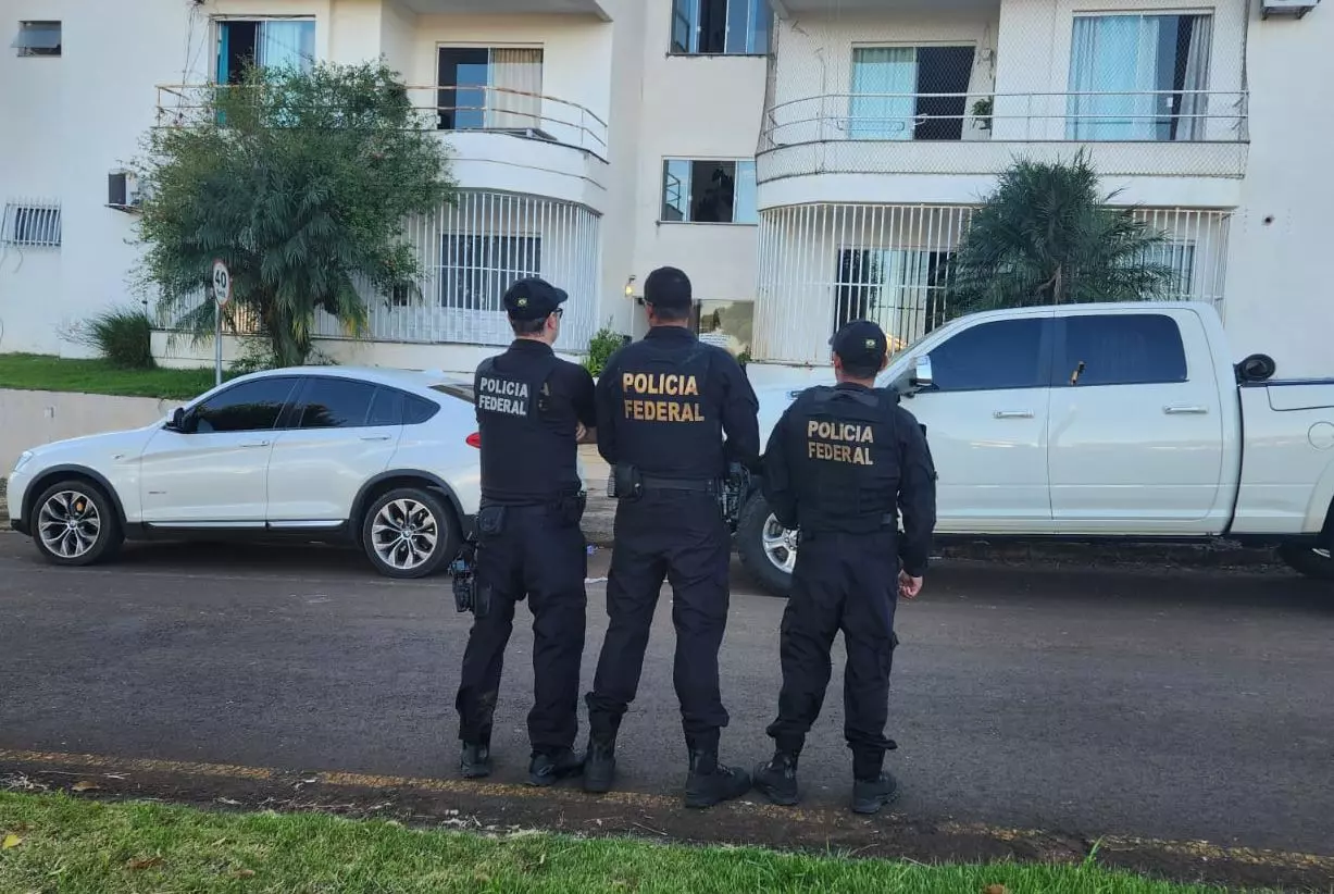 Agentes em frente a veículos de alto valor confiscados (Foto: Polícia Federal)