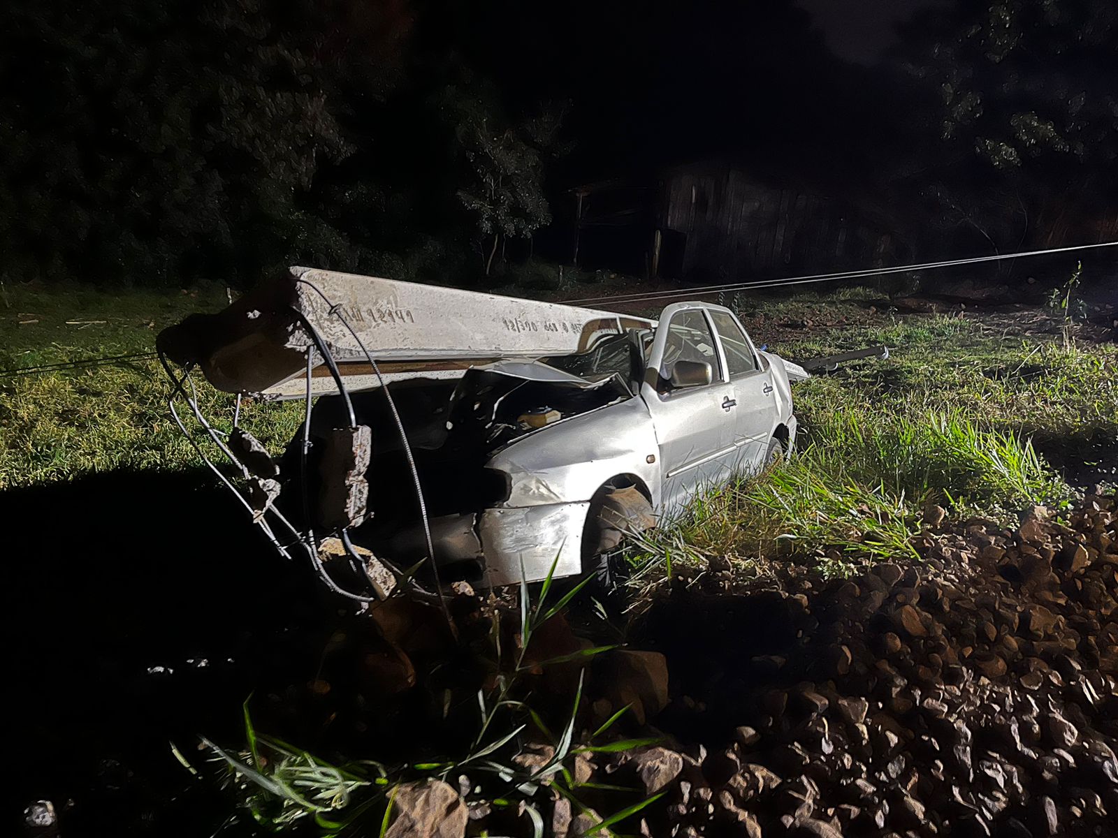 Poste amassou automóvel (Foto: Corpo de Bombeiros)