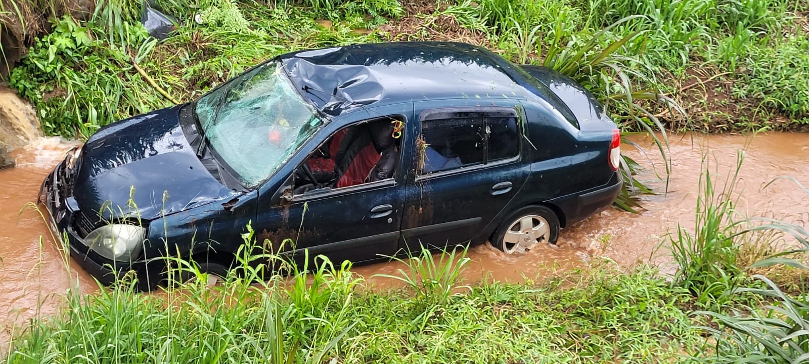 Clio sai da pista e cai em córrego de água